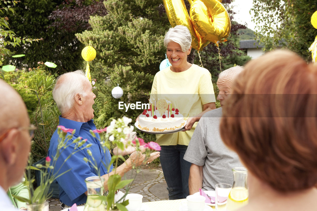 Mature woman serving birthday cake