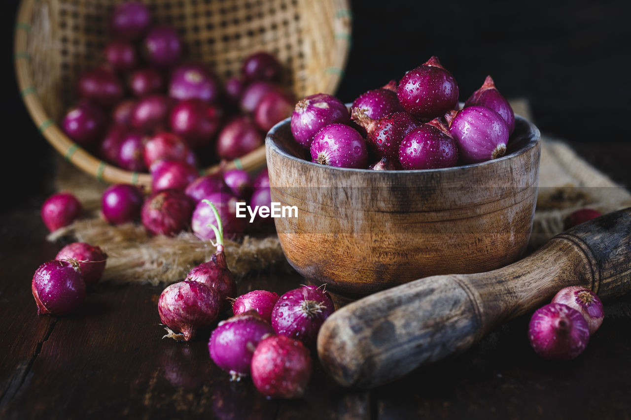 Close-up of wet shallots with mortar and pestle on table