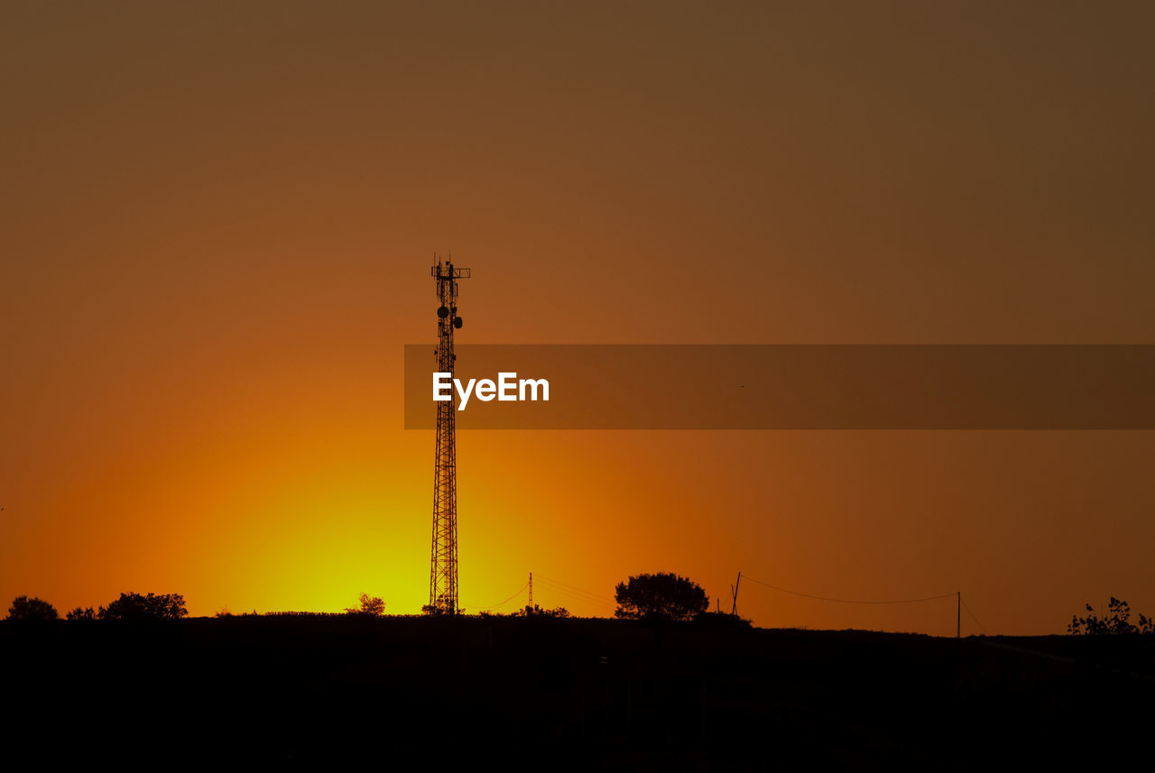 Low angle view of silhouette tower against sky during sunset