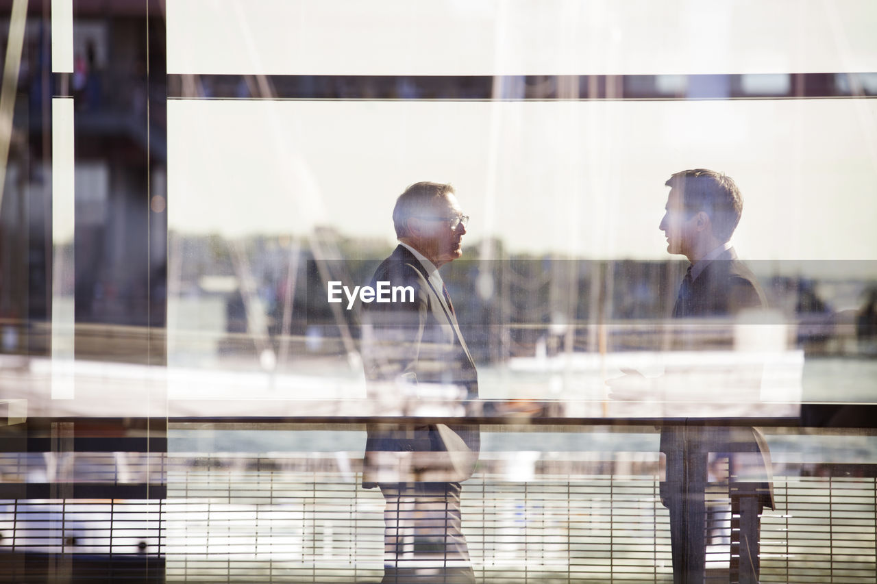 Businessmen standing against railing