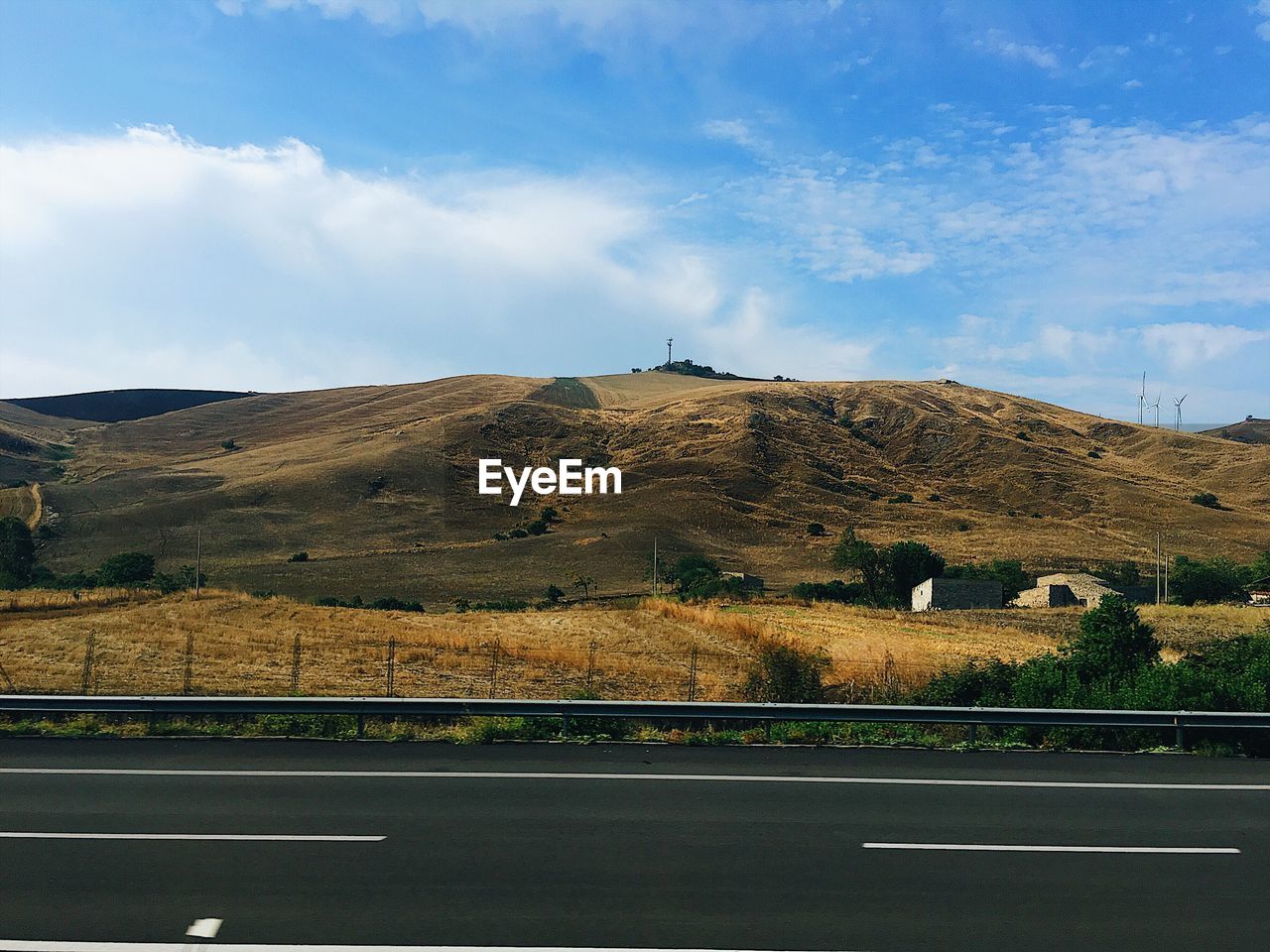 Road leading towards mountain against sky