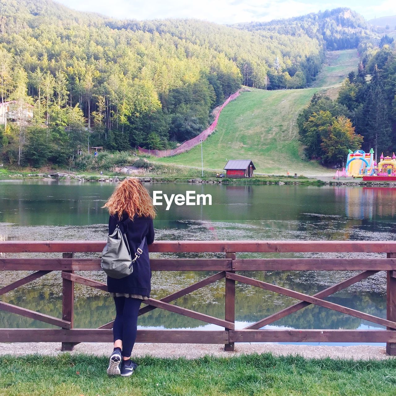 FULL LENGTH REAR VIEW OF WOMAN LOOKING AT LAKE AGAINST MOUNTAIN