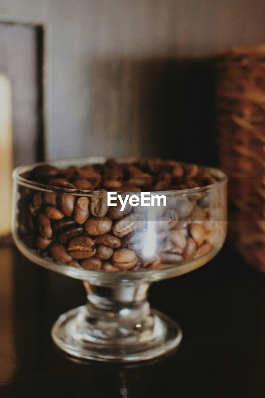 CLOSE-UP OF COFFEE CUP ON TABLE AGAINST WALL