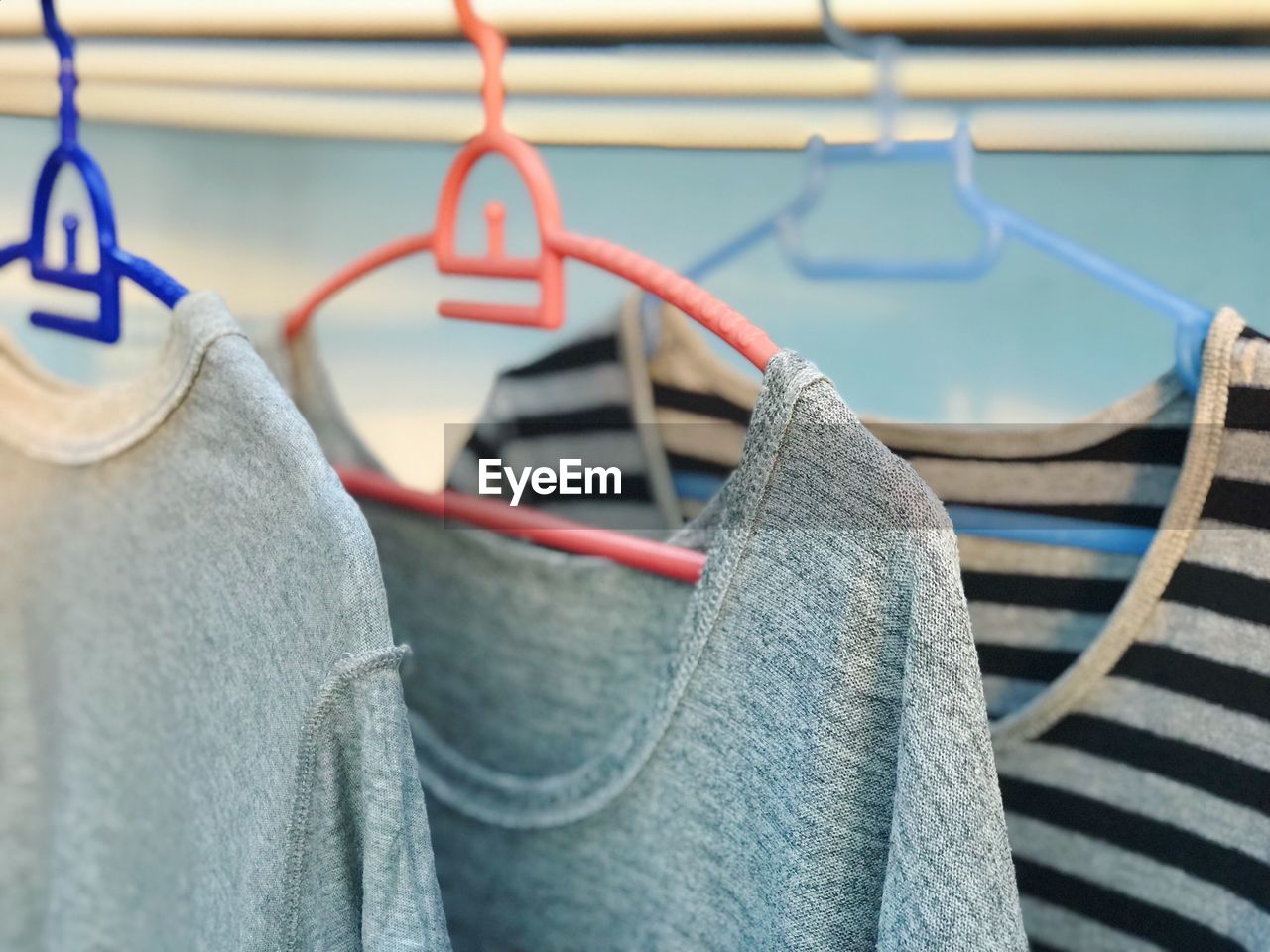 CLOSE-UP OF CLOTHES HANGING ON CLOTHESLINE AGAINST BLURRED BACKGROUND