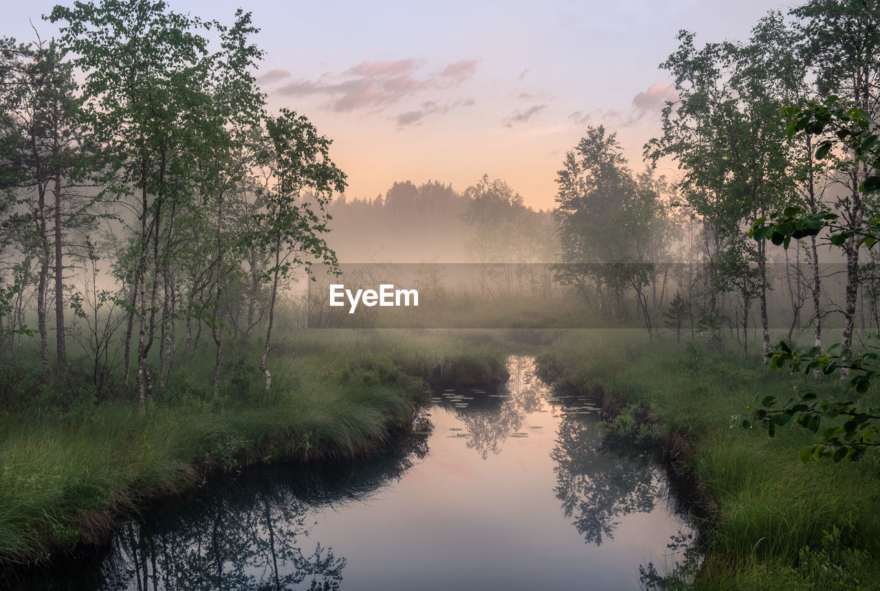 SCENIC VIEW OF LAKE AGAINST SKY AT SUNSET