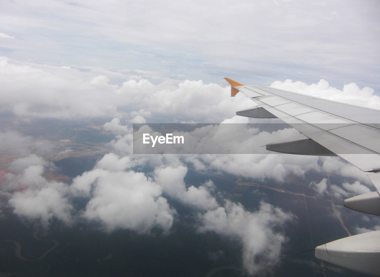 AERIAL VIEW OF CLOUDSCAPE OVER AIRPLANE WING