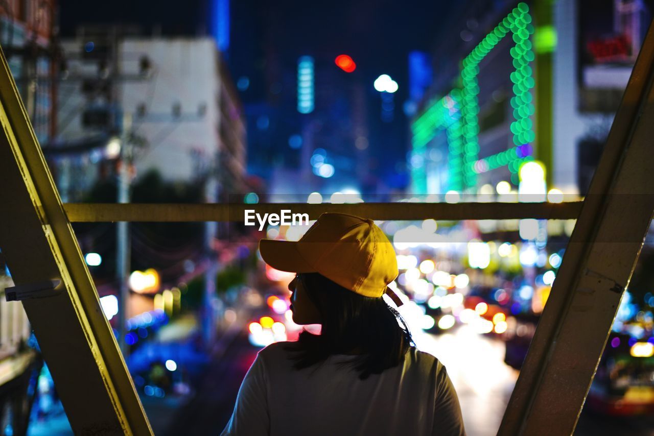 Rear view of woman in city at night