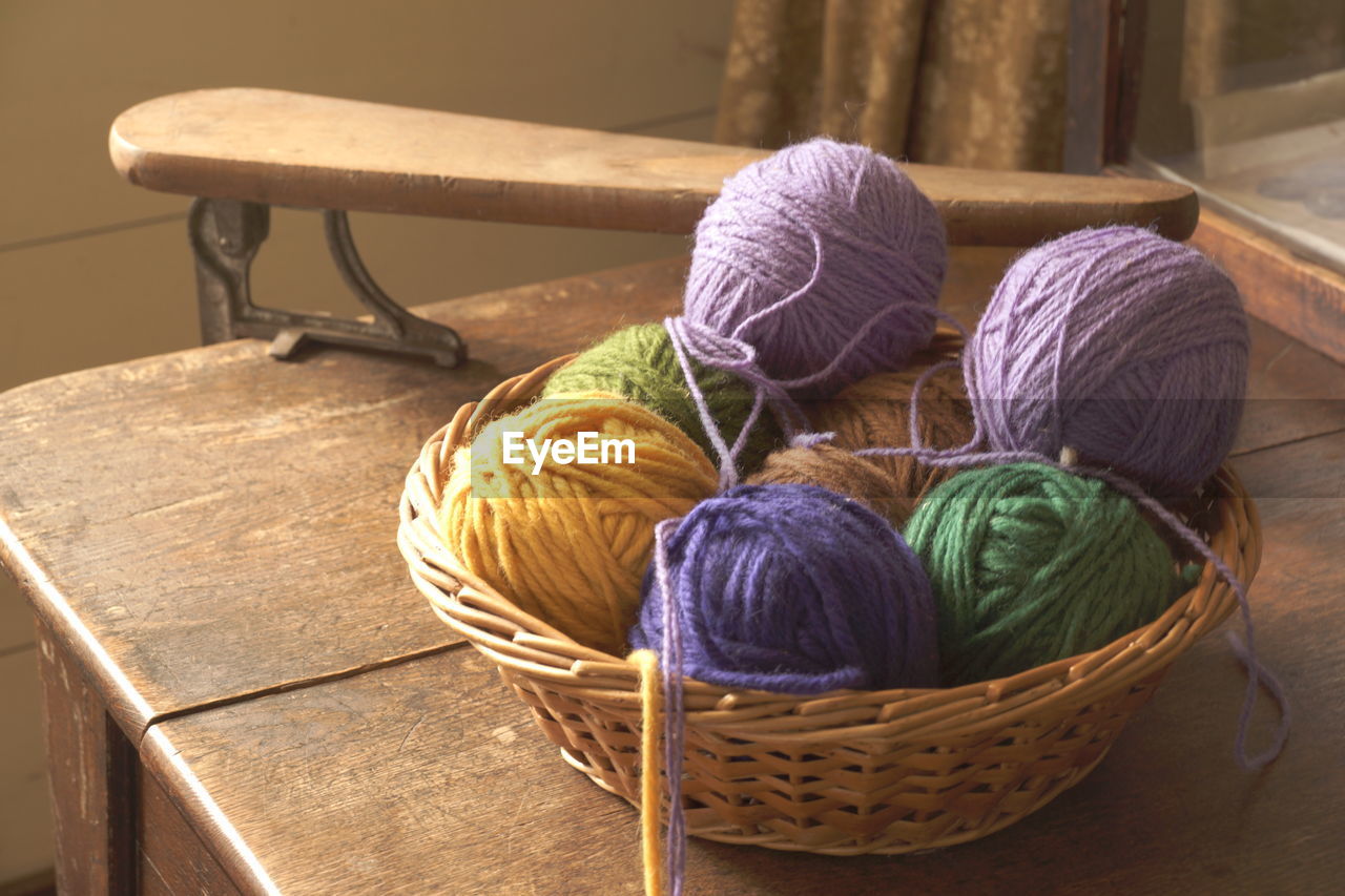 High angle view of colorful ball of wools in container on table
