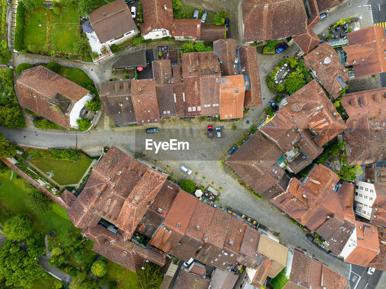 Aerial view of residential area with streets and roofs on summer morning.