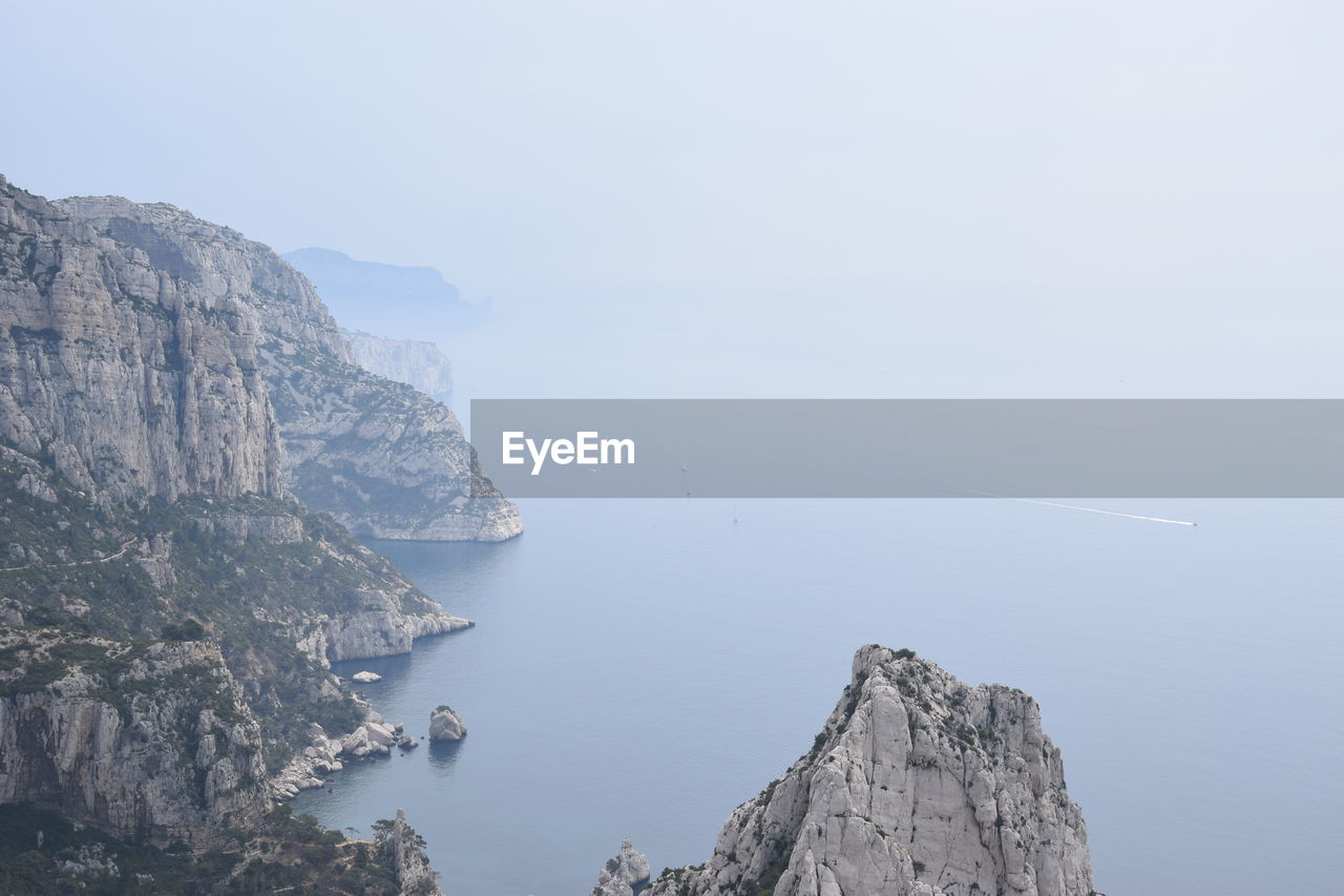 Rock formations by sea against sky