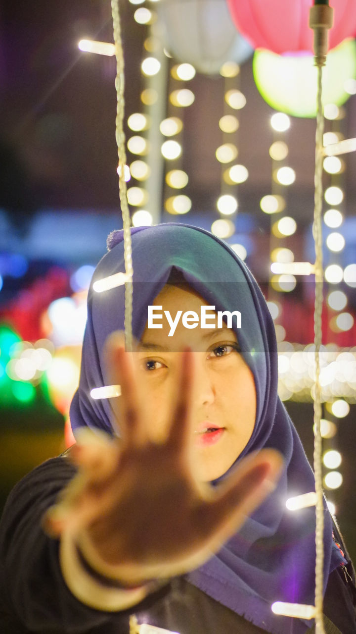 one person, portrait, illuminated, night, headshot, young adult, adult, celebration, looking at camera, women, front view, focus on foreground, lighting equipment, holding, decoration, amusement park, child, arts culture and entertainment, leisure activity, lifestyles, clothing, looking, emotion, outdoors, childhood