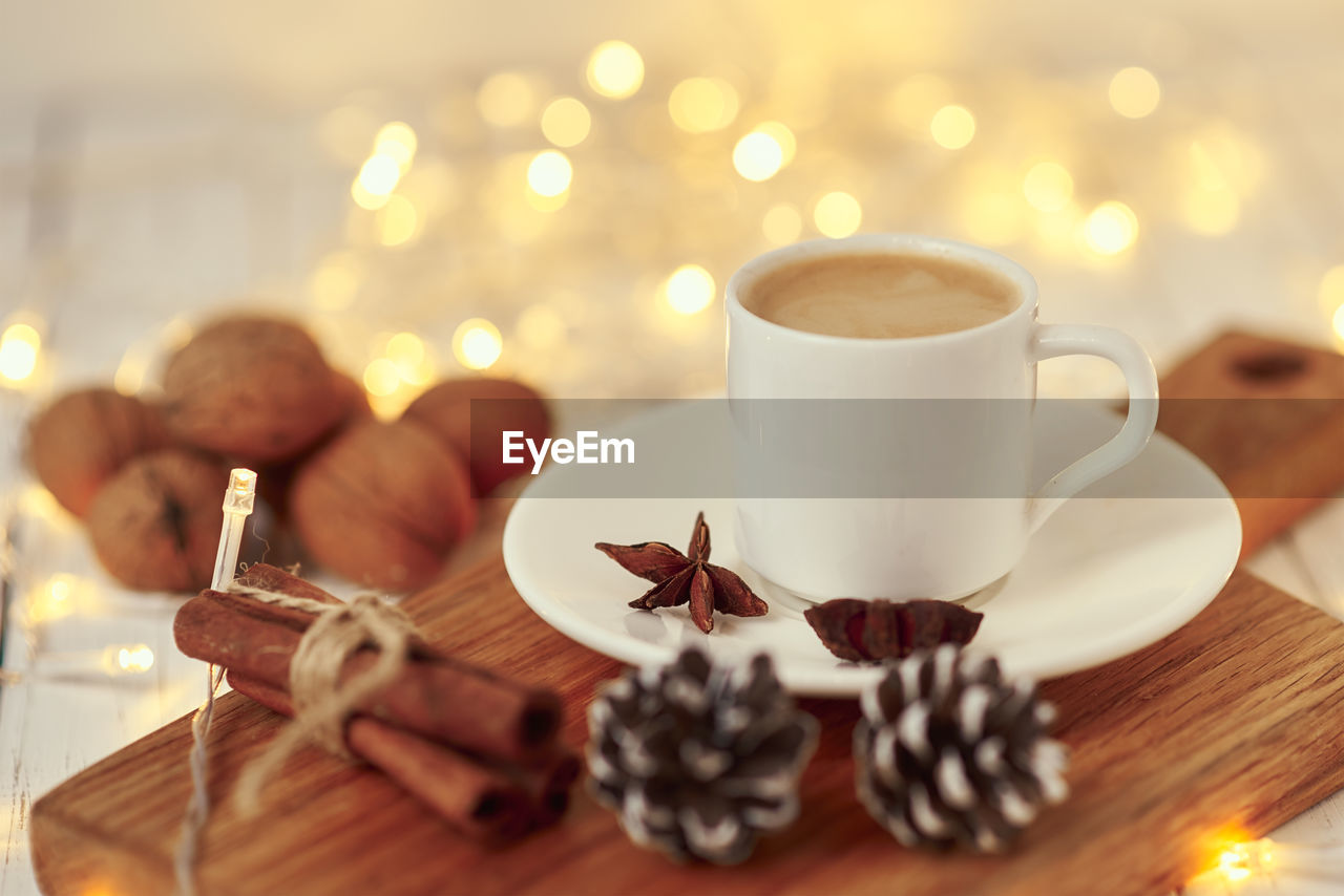 Cozy autumn or winter concept. cup of coffee with garland lights and decoration/