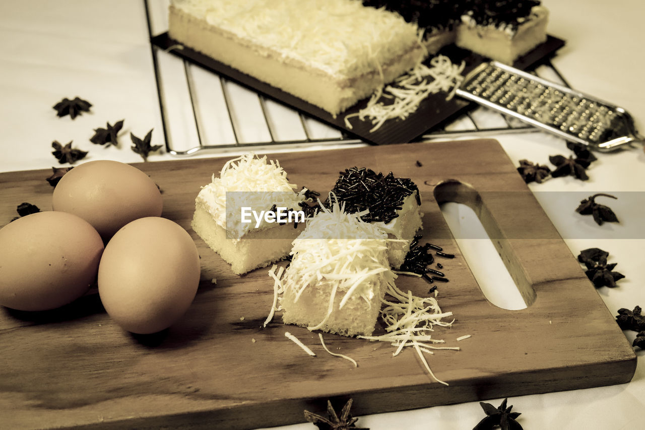 HIGH ANGLE VIEW OF EGGS IN CONTAINER ON WOODEN TABLE