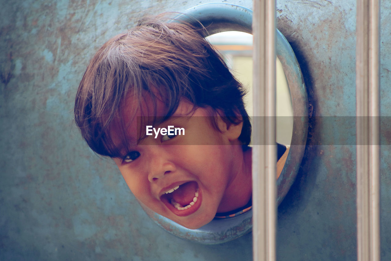 Portrait of boy seen through play equipment