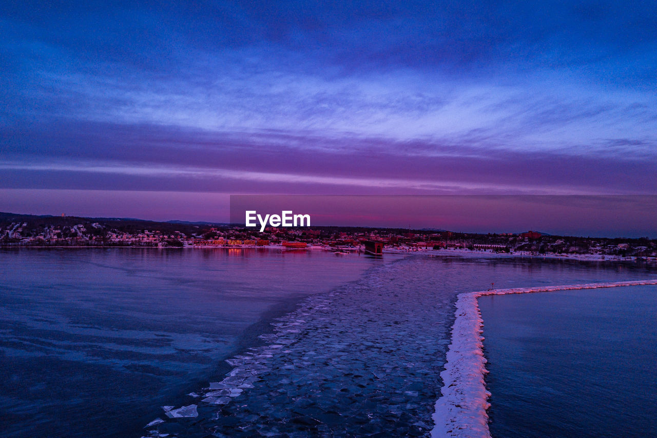 SCENIC VIEW OF BEACH AGAINST SKY DURING SUNSET