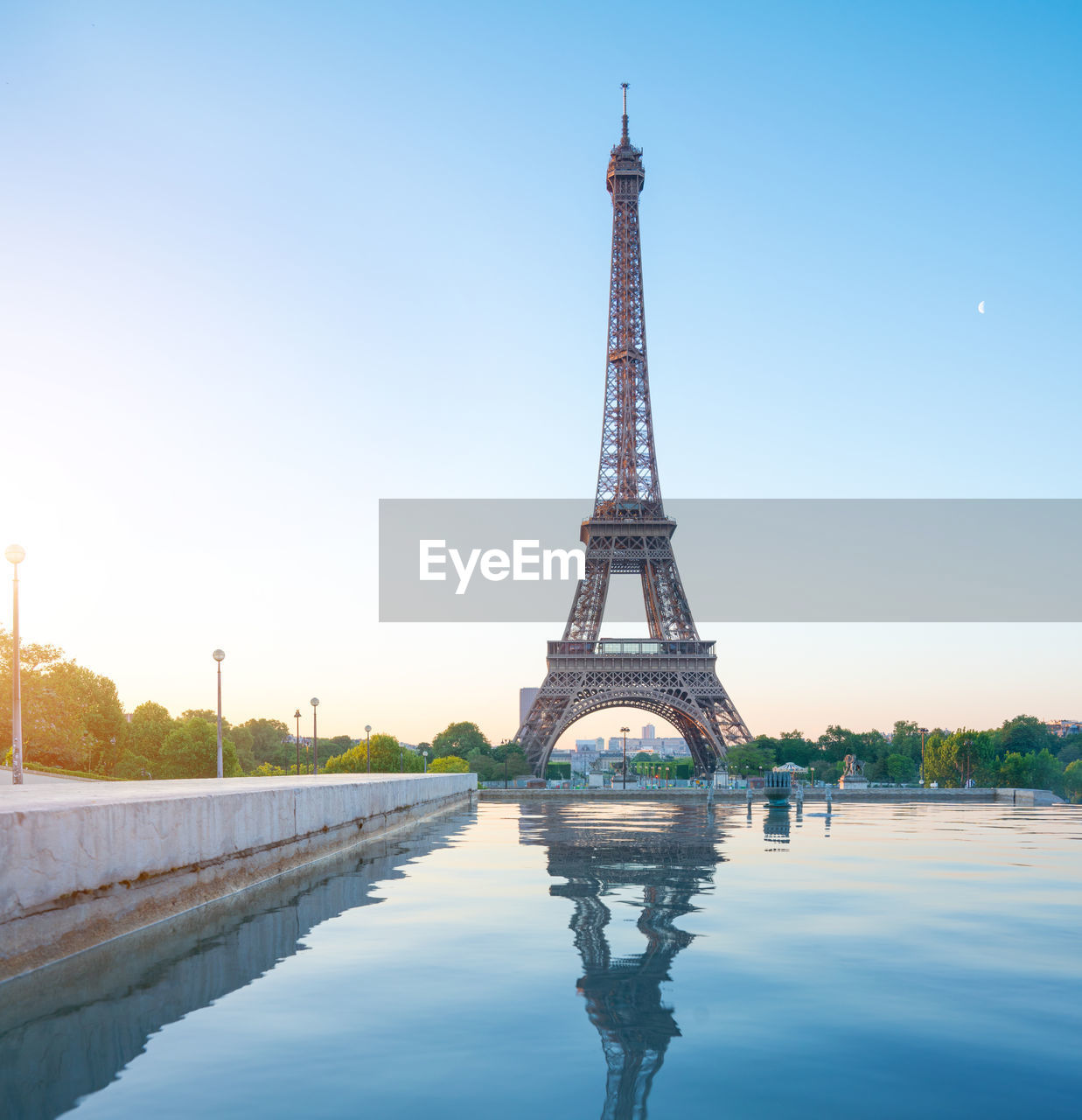 Reflection of eiffel tower in pond against sky