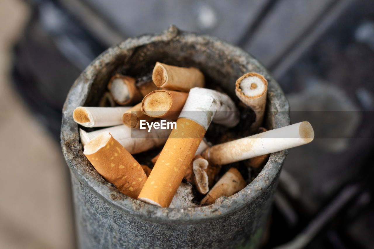 High angle view of cigarette butts in container