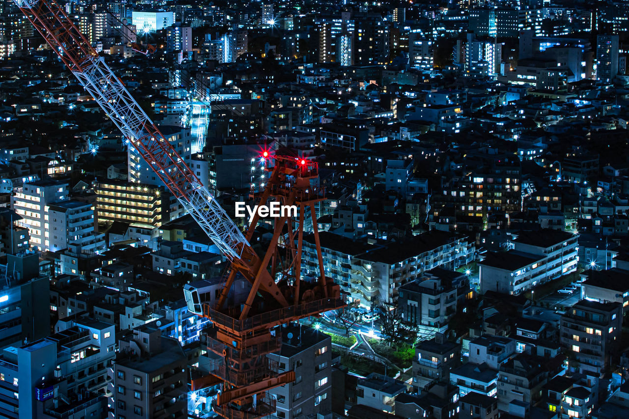 HIGH ANGLE VIEW OF ILLUMINATED MODERN BUILDINGS AT NIGHT