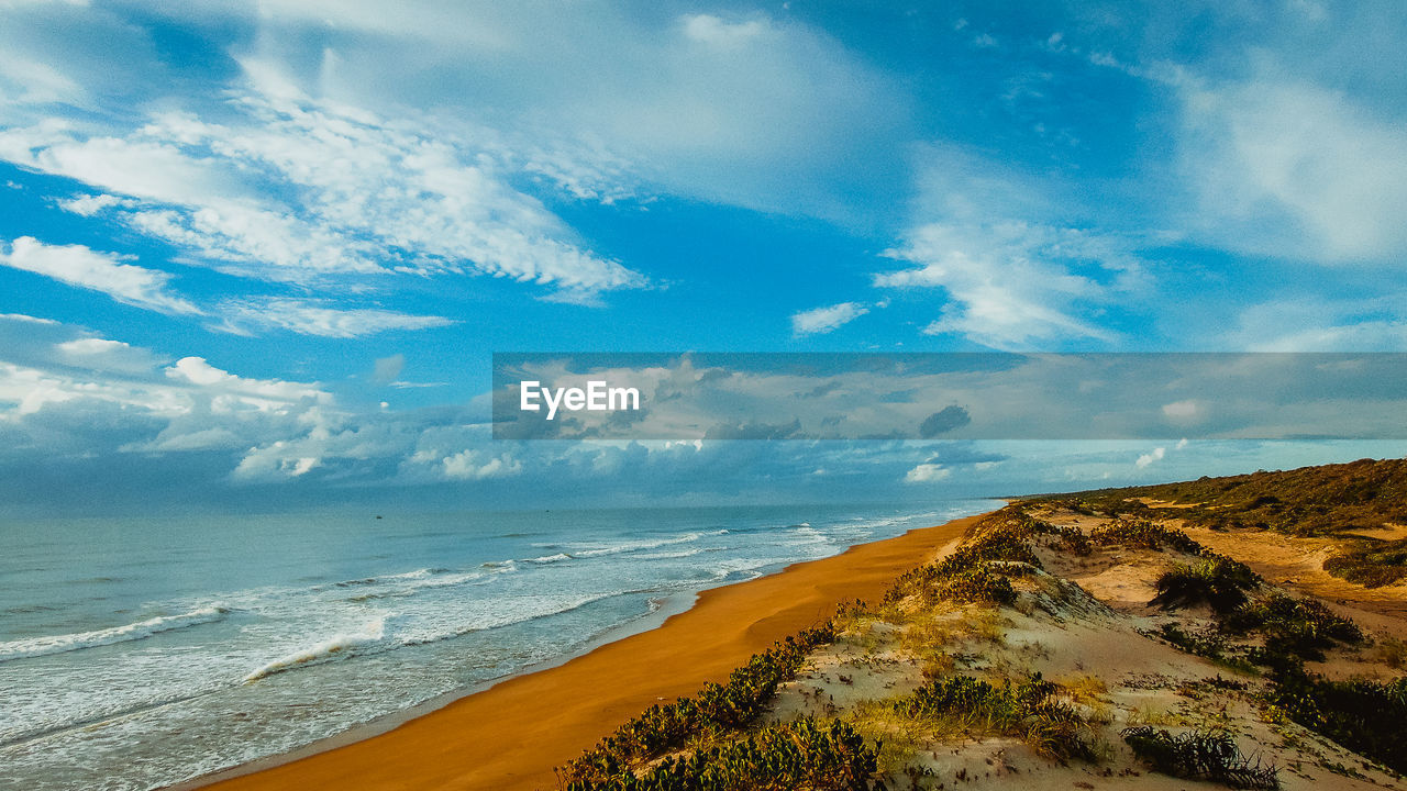 Scenic view of sea and beach against cloudy sky