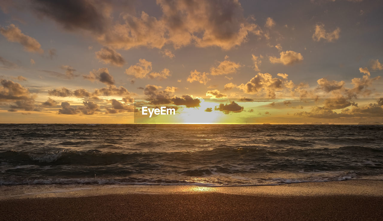 SCENIC VIEW OF BEACH AGAINST SKY AT SUNSET