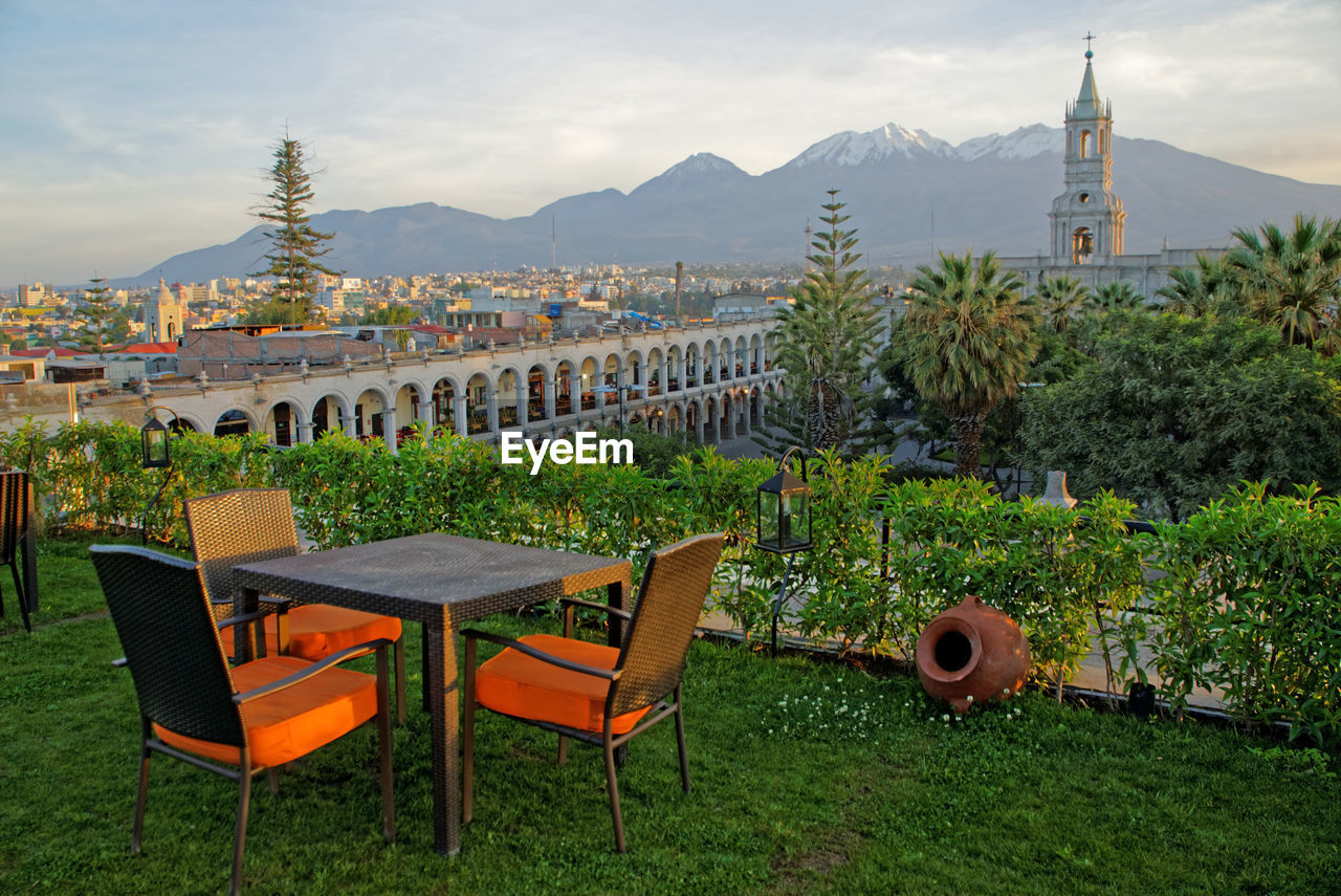 CHAIRS AND TABLES IN FRONT OF BUILDINGS