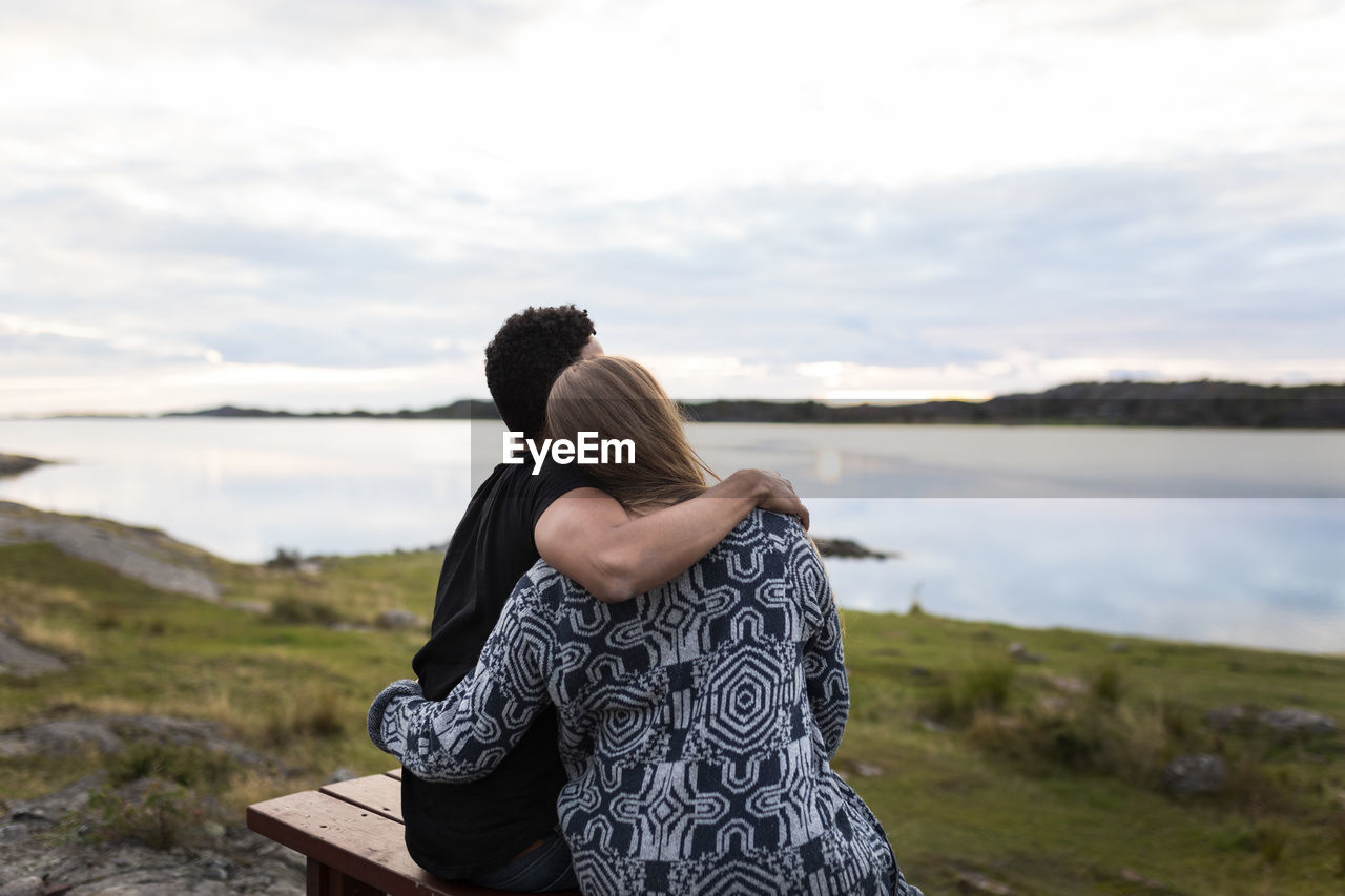 Couple embracing and looking at lake