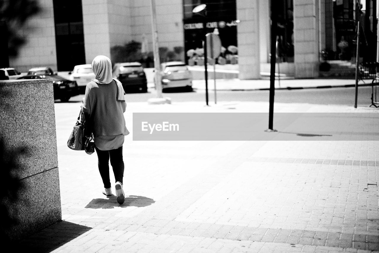 Woman in hijab walking on pavement