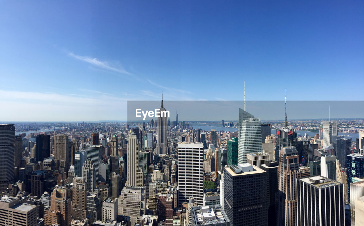 Manhattan against blue sky on sunny day