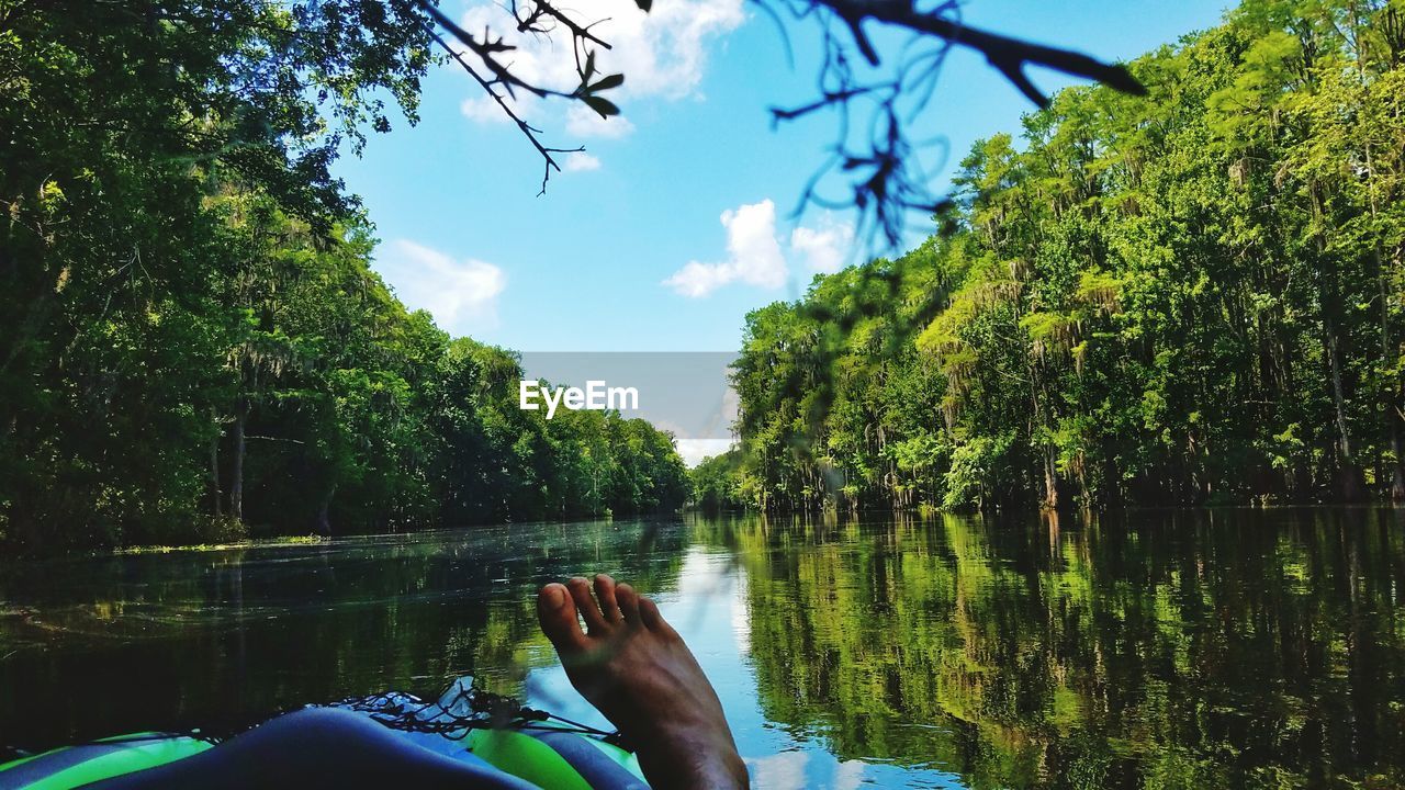 Feet of person on raft in river