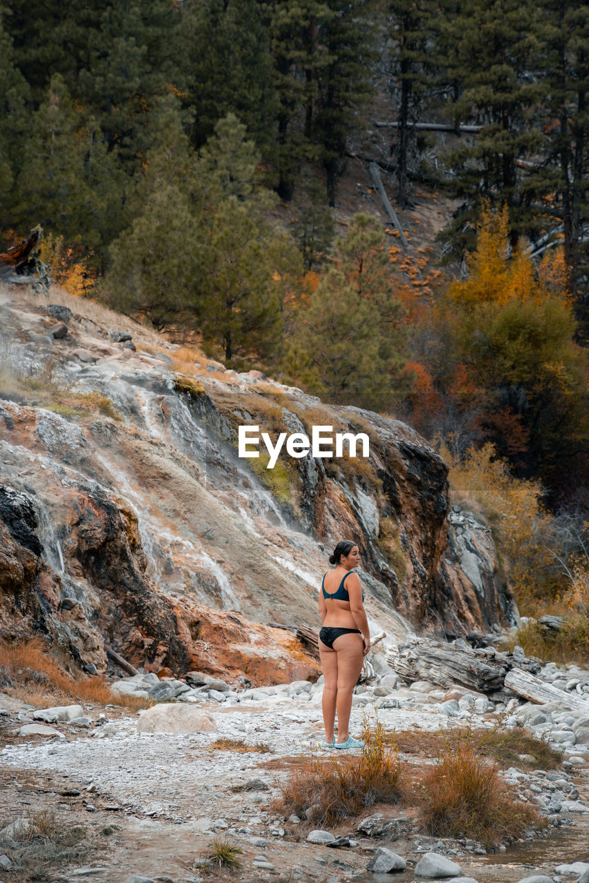 Woman standing in bikini and looking out near a hot spring area in idaho