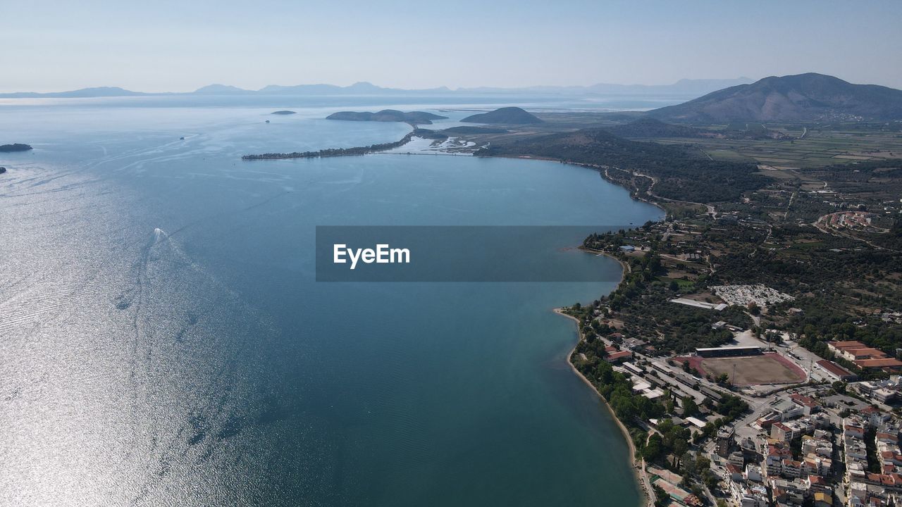 HIGH ANGLE VIEW OF CITY AND SEA AGAINST SKY