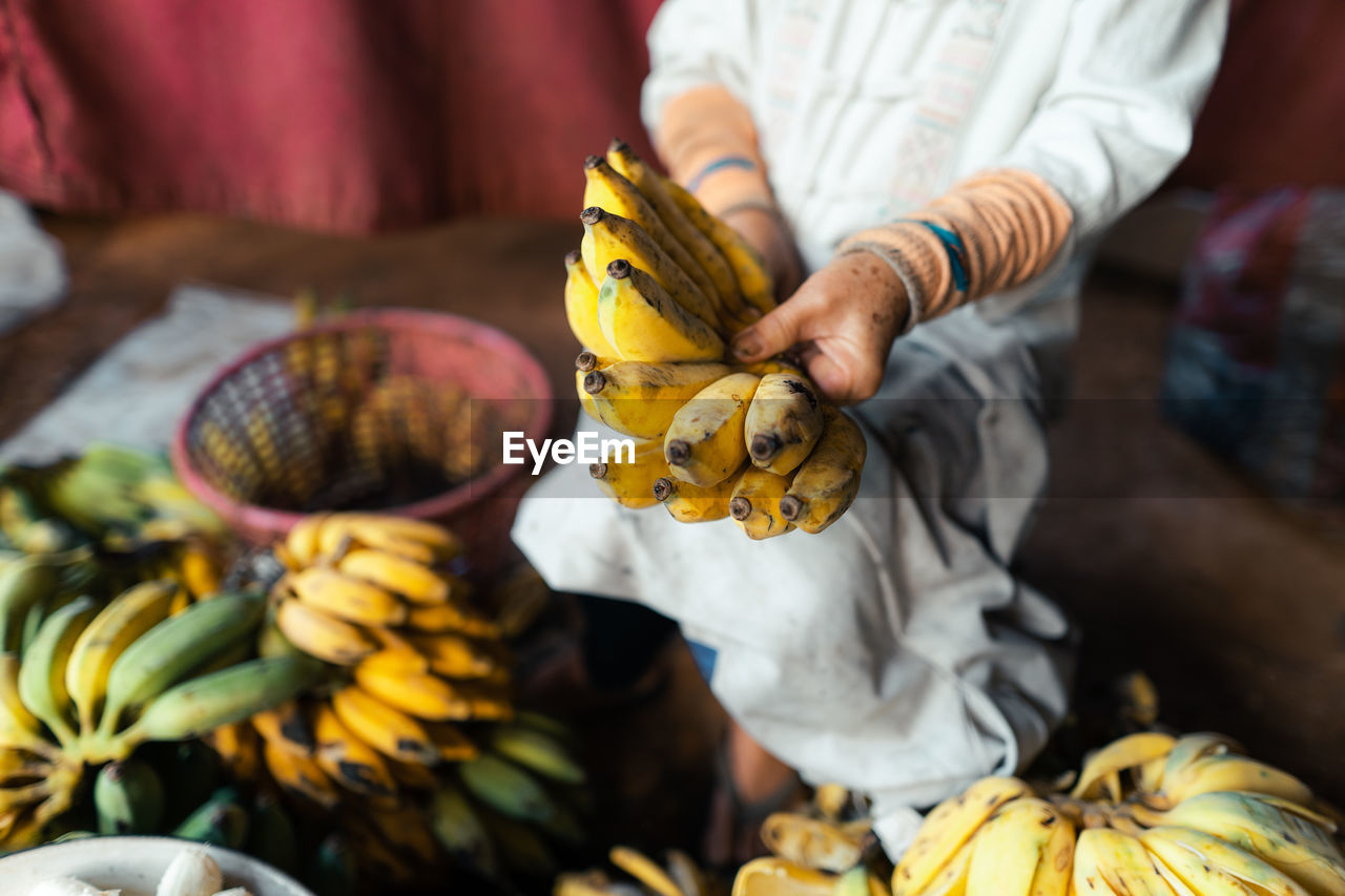 midsection of man holding fruit