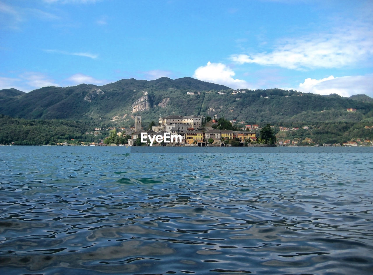 Scenic view of lake and mountains against blue sky