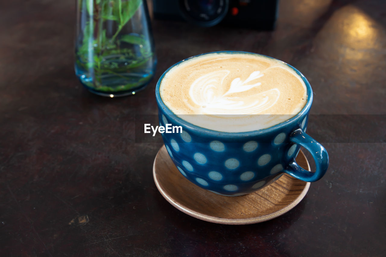 CLOSE-UP OF COFFEE CUP ON TABLE WITH SPOON