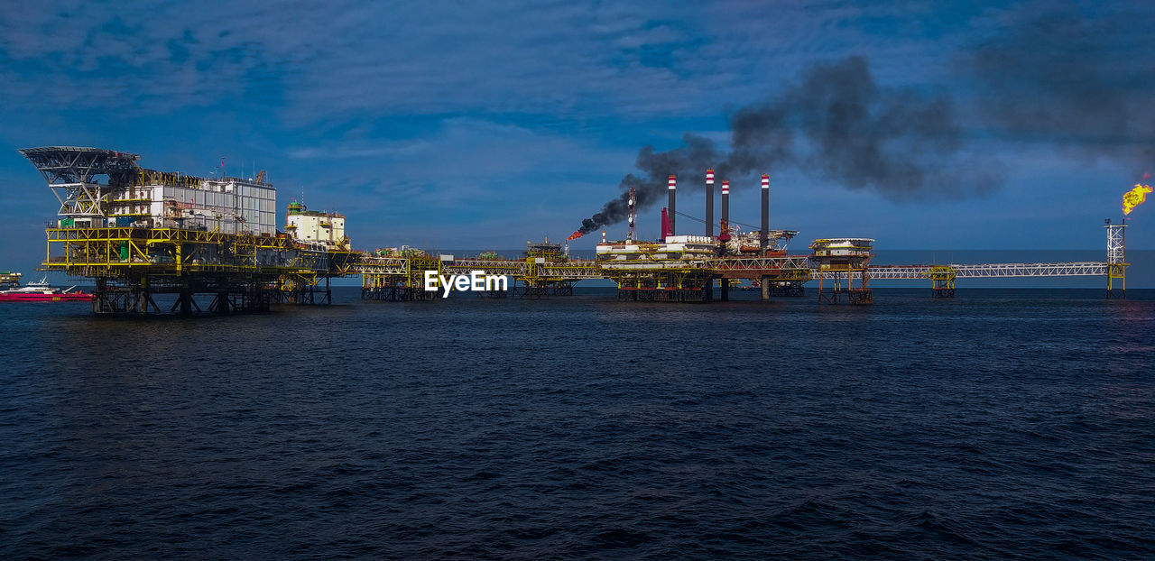 Commercial dock by sea against sky