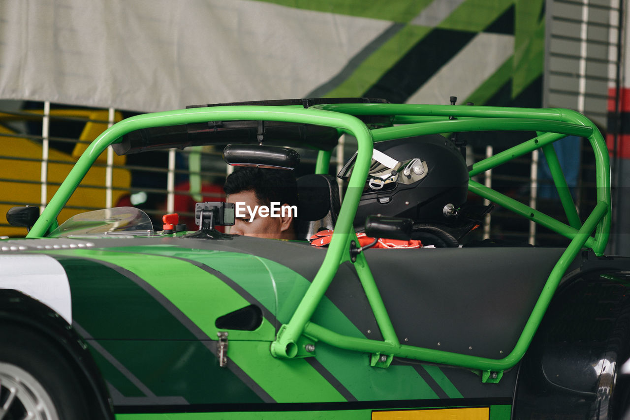 Mechanic sitting in car at garage
