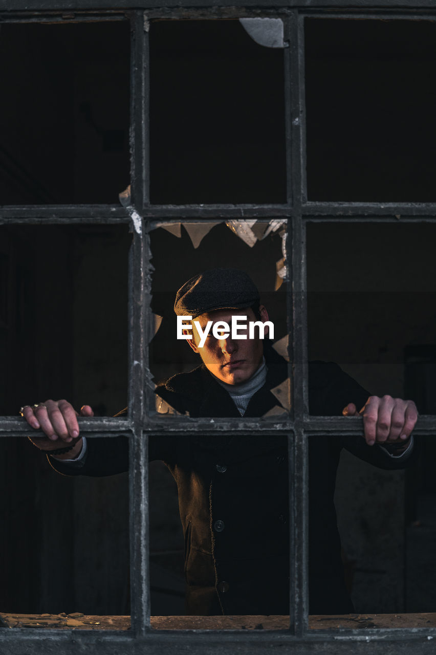 Young man looking through prison bar