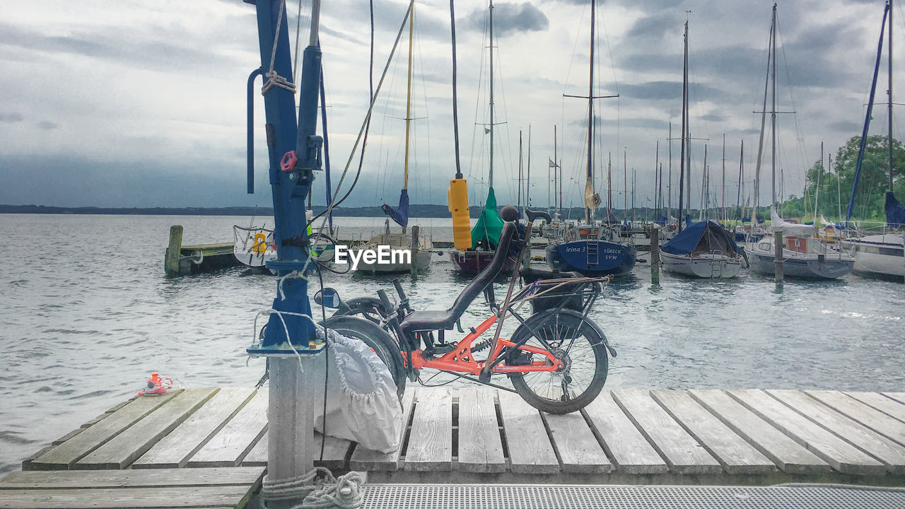 BOATS MOORED AT SEA AGAINST SKY