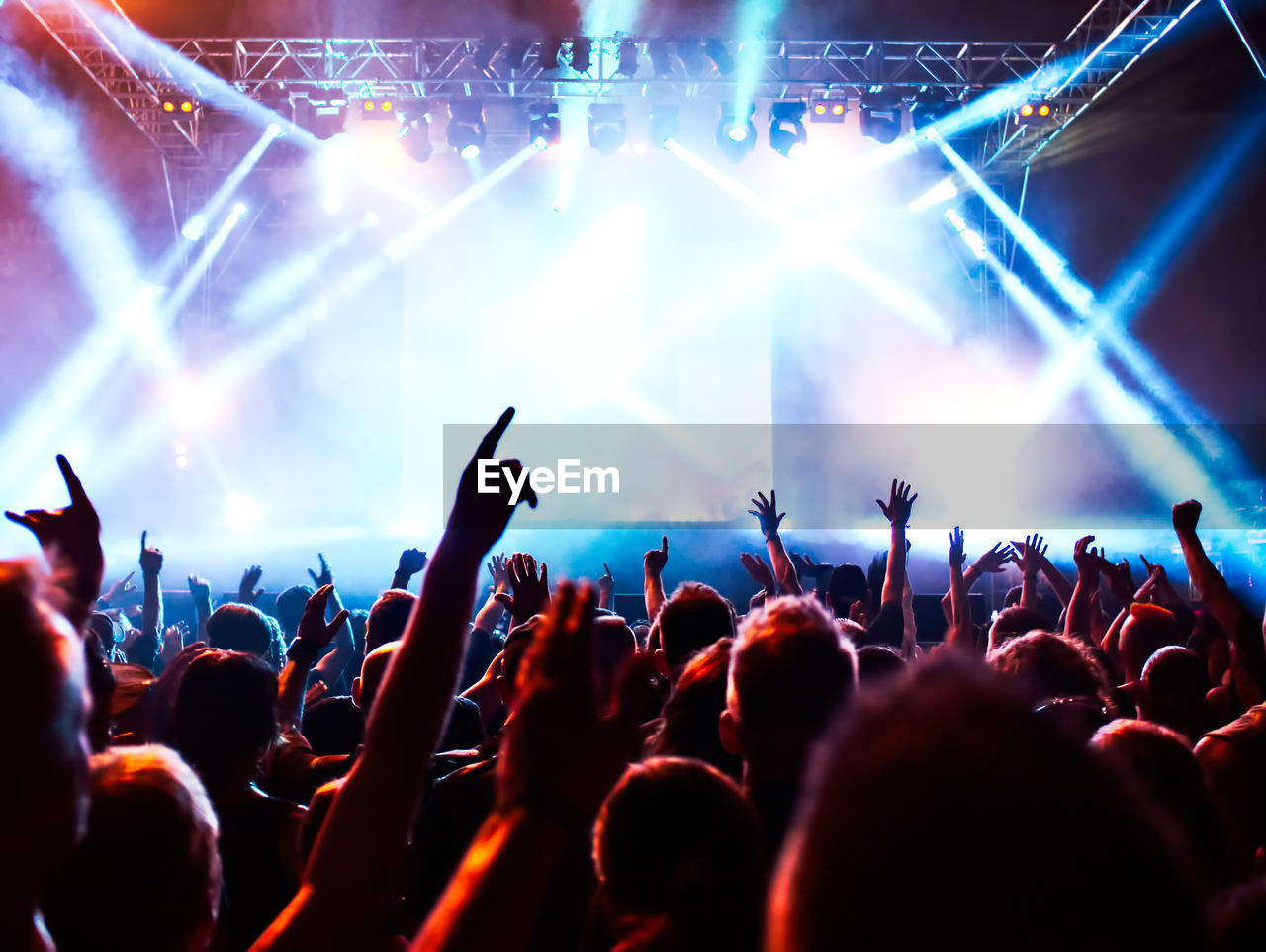 Group of people with arms raised at music concert