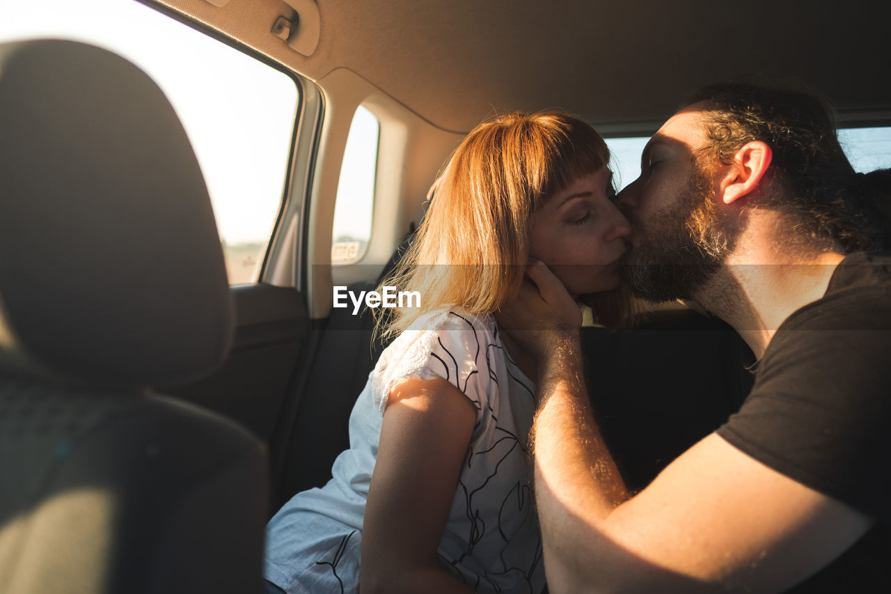 Couple kissing while sitting in car