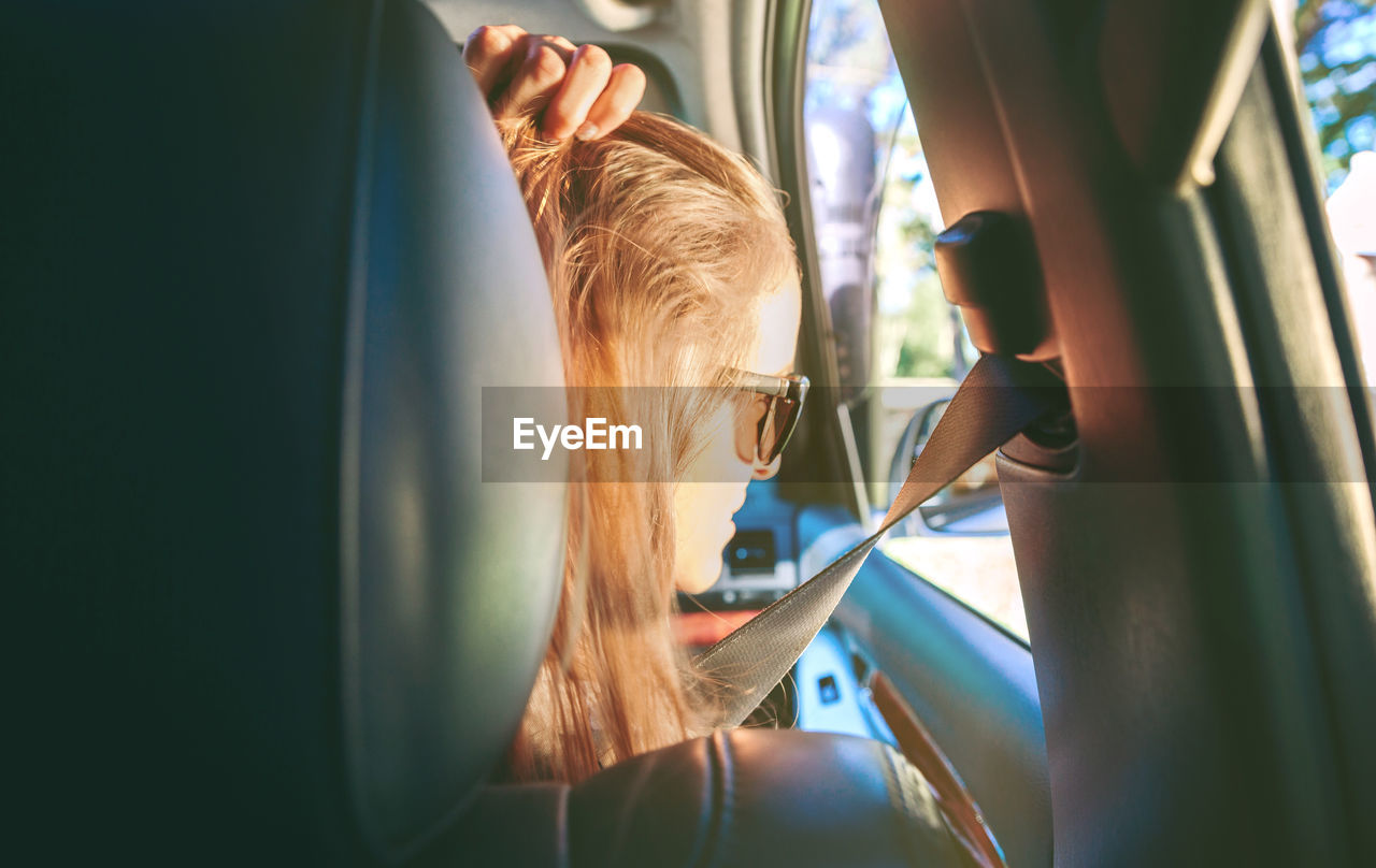 Rear view of young woman sitting in car