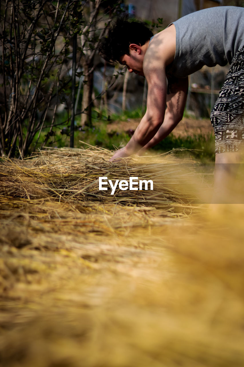 Midsection of man on field in forest