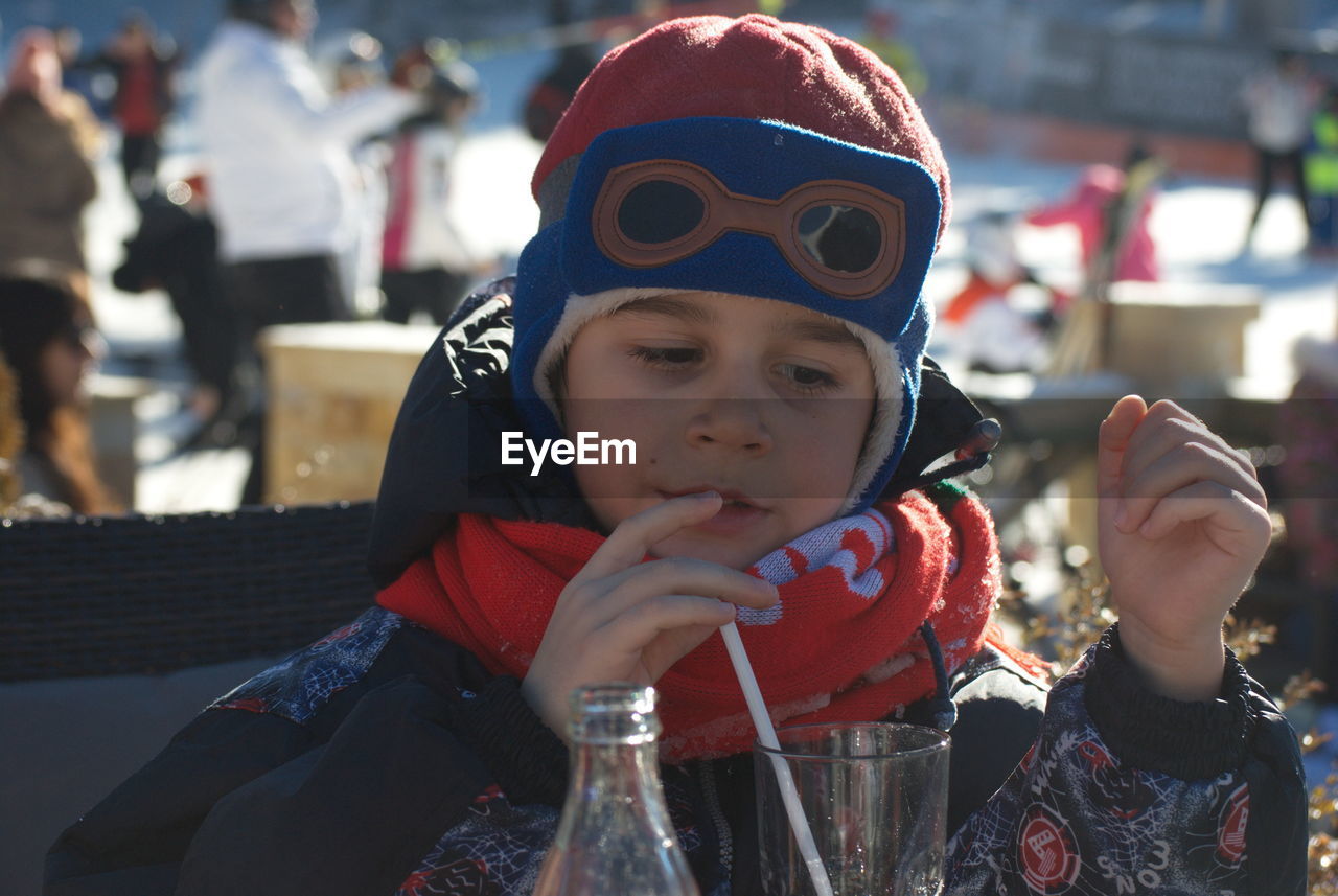 PORTRAIT OF CUTE BOY DRINKING BEER