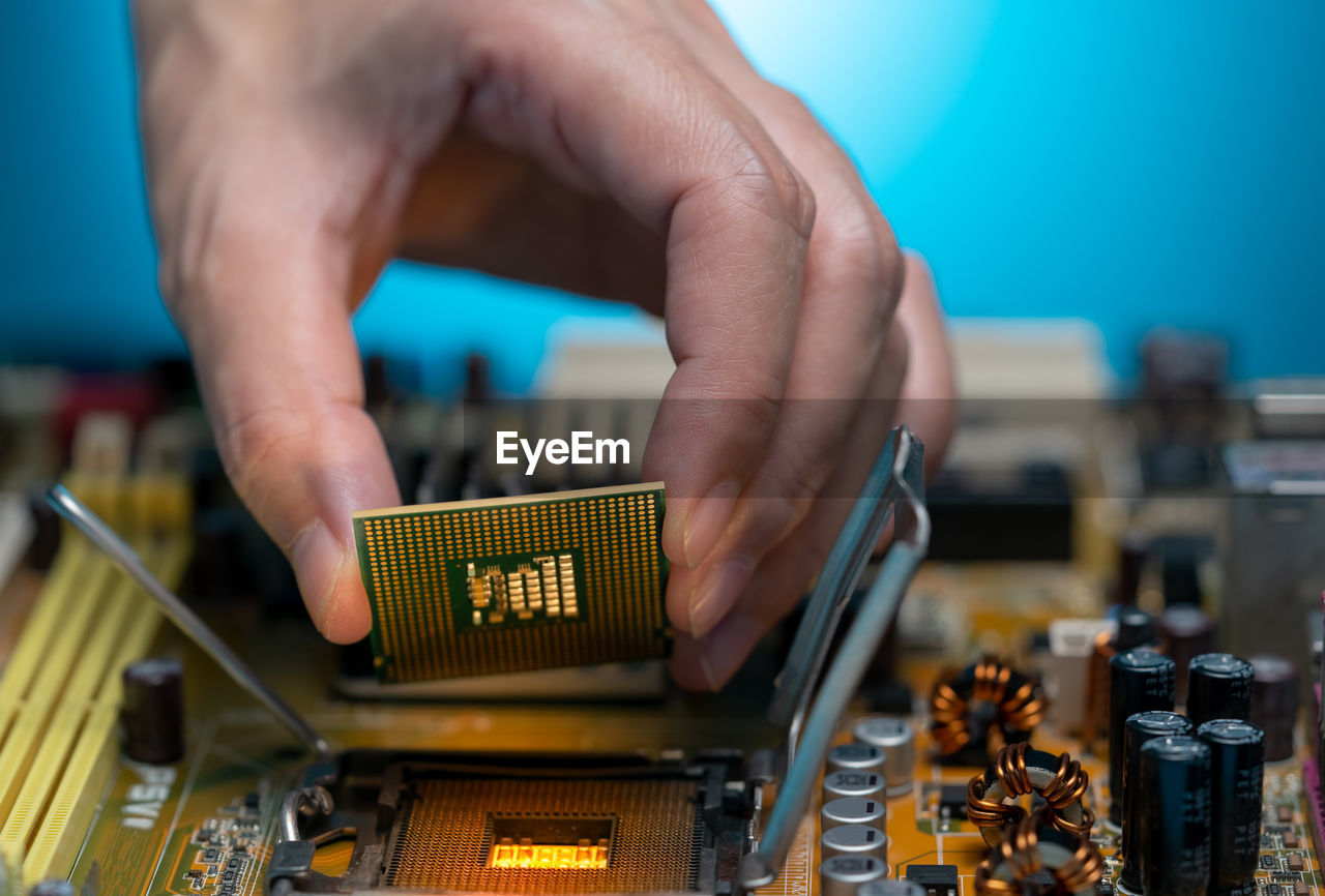 Electronic engineer hand putting computer chip on socket. chipset on electronic circuit board of pc