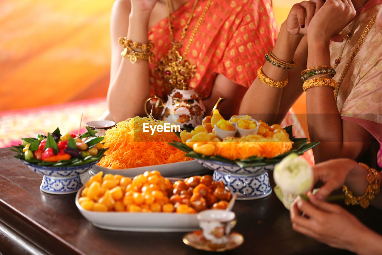 Midsection of women having food at table