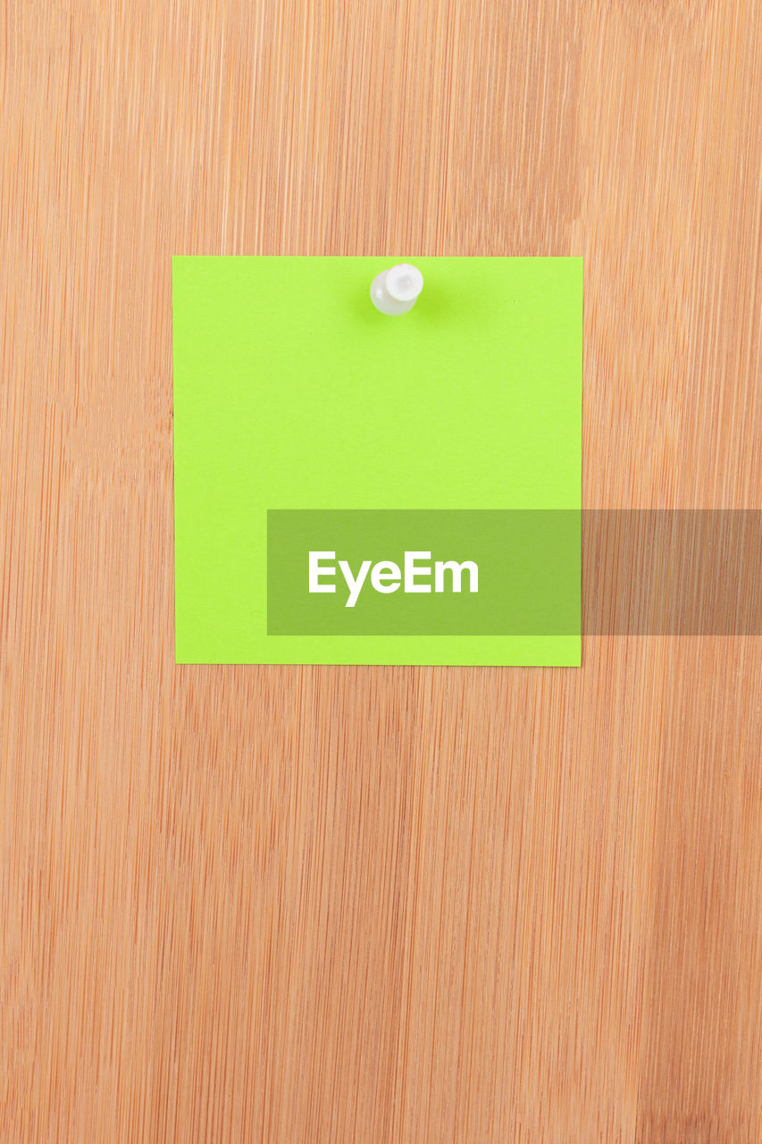 CLOSE-UP OF GREEN COLORED PENCILS ON WOODEN SURFACE