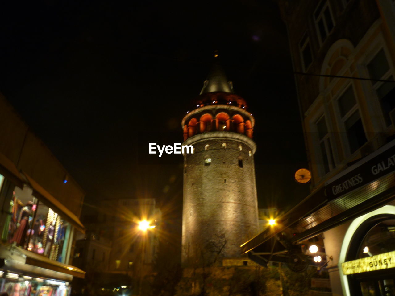 LOW ANGLE VIEW OF ILLUMINATED BUILDINGS AT NIGHT