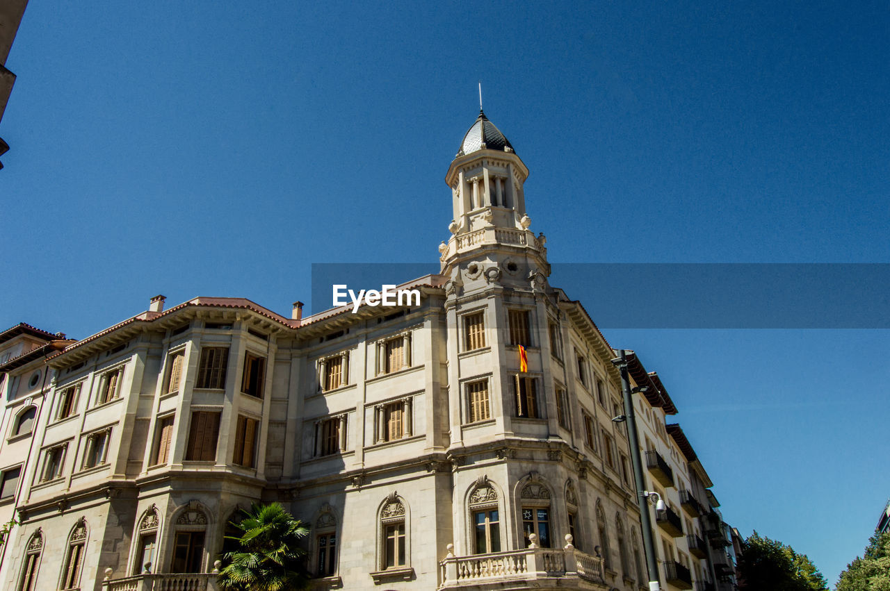 Low angle view of historic building against clear blue sky