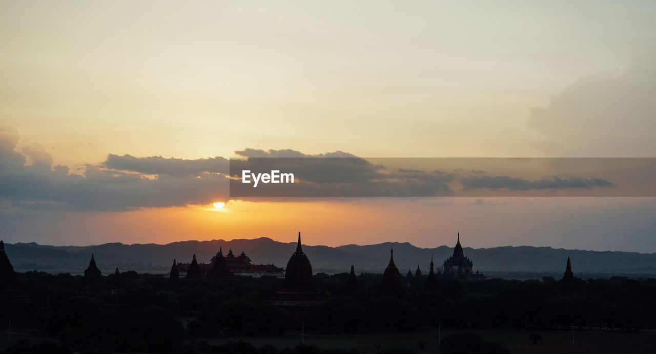 Silhouette pagoda against sky during sunset