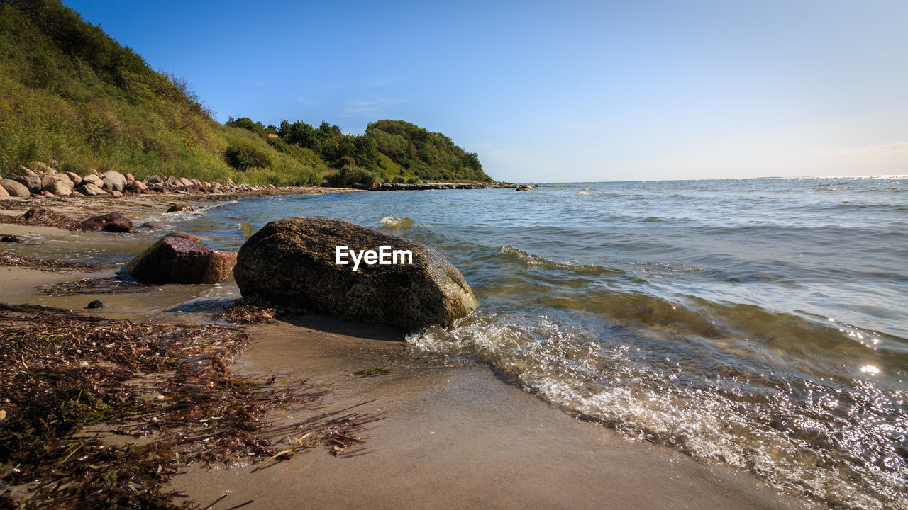 ROCKS ON BEACH AGAINST SKY